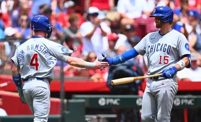 Chicago Cubs' Pete Crow-Armstrong, left, celebrates with Carson Kelly, right, after scoring on a double hit by Alex Bregman during the first inning of a baseball game against the Cincinnati Reds in Cincinnati, Sunday, July 12, 2026. (AP Photo/Ben Jackson)