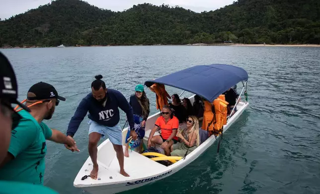 Fisherman Reinaldo Dias da Rocha boards a boat used by a shark protection project at Ilha Grande Bay, Angra dos Reis, Rio de Janeiro state, Brazil, July 14, 2026. (AP Photo/Bruna Prado)