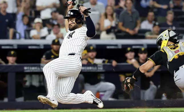 New York Yankees' Jasson Domínguez scores a run past Pittsburgh Pirates catcher Rafael Flores Jr. in the seventh inning during the second baseball game of a doubleheader, Wednesday, July 22, 2026, in New York. (AP Photo/Adam Hunger)