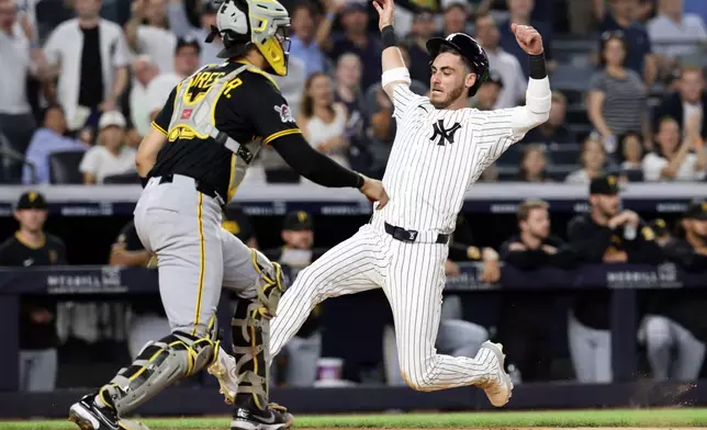 New York Yankees' Cody Bellinger scores a run past Pittsburgh Pirates catcher Rafael Flores Jr. in the seventh inning during the second baseball game of a doubleheader, Wednesday, July 22, 2026, in New York. (AP Photo/Adam Hunger)