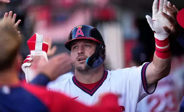 Los Angeles Angels' Mike Trout is congratulated by teammates in the dugout after scoring on a double by Jorge Soler during the first inning of a baseball game against the St. Louis Cardinals, Tuesday, July 21, 2026, in Anaheim, Calif. (AP Photo/Mark J. Terrill)