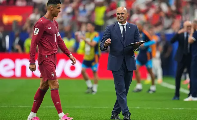 Portugal head coach Roberto Martinez, right, gives instructions to Cristiano Ronaldo (7) during the World Cup round of 16 soccer match between Portugal and Spain in Arlington, Texas, near Dallas, Monday, July 6, 2026. (AP Photo/Julio Cortez)