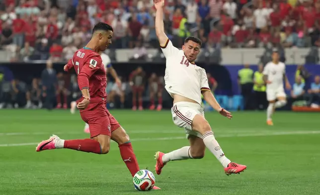 Portugal's Cristiano Ronaldo (7) shoots by Spain's Aymeric Laporte (14) during the World Cup round of 16 soccer match between Portugal and Spain in Arlington, Texas, near Dallas, Monday, July 6, 2026. (AP Photo/Gareth Patterson)