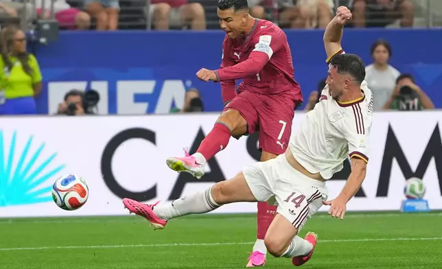 Portugal's Cristiano Ronaldo (7) attempts a shot on goal challenged by Spain's Aymeric Laporte (14) during the World Cup round of 16 soccer match between Portugal and Spain in Arlington, Texas, near Dallas, Monday, July 6, 2026. (AP Photo/Julio Cortez)