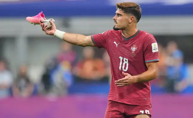 Portugal's Pedro Neto (18) shows his shoe to the referee during the World Cup round of 16 soccer match between Portugal and Spain in Arlington, Texas, near Dallas, Monday, July 6, 2026. (AP Photo/Julio Cortez)