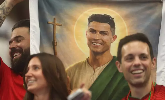 Fans hold a poster showing Portugal's Cristiano Ronaldo (7) before the World Cup round of 16 soccer match between Portugal and Spain in Arlington, Texas, near Dallas, Monday, July 6, 2026. (AP Photo/Gareth Patterson)