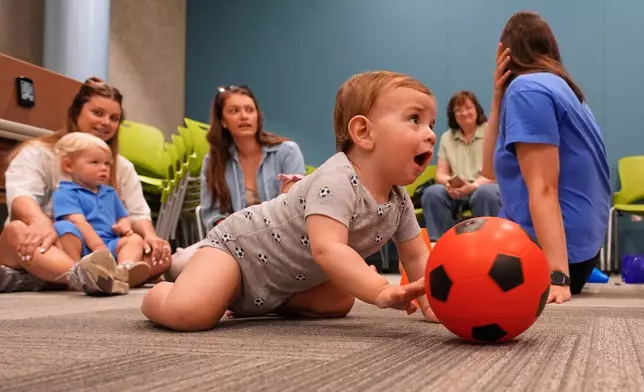 Ten-month-old Beck Ehinger plays with a soccer ball at a program introducing toddlers to the sport ahead of the World Cup soccer tournament Thursday, June 4, 2026, in Lenexa, Kan. (AP Photo/Charlie Riedel)