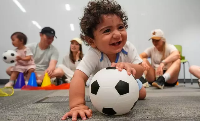 Ten-month-old Zain Fawaz plays with a soccer ball at a program introducing toddlers to the sport ahead of the World Cup soccer tournament Thursday, June 4, 2026, in Lenexa, Kan. (AP Photo/Charlie Riedel)