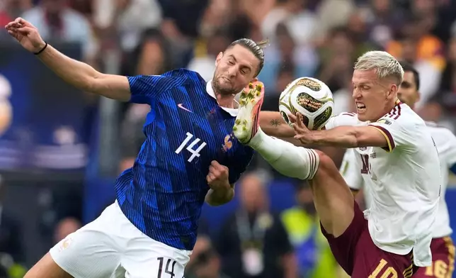Spain's Dani Olmo (10) and France's Adrien Rabiot (14) fight for the ball during the World Cup semifinal soccer match between France and Spain in Arlington, Texas, near Dallas, Tuesday, July 14, 2026. (AP Photo/Tony Gutierrez)