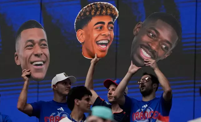 France fans hold pictures of France's Kylian Mbappe (10), left, Spain's Lamine Yamal (19), center, and France's Ousmane Dembele (7) before the World Cup semifinal soccer match between France and Spain in Arlington, Texas, near Dallas, Tuesday, July 14, 2026. (AP Photo/Tony Gutierrez)