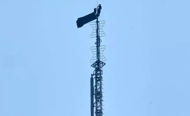 A person is shown atop the spire of the Empire State Building, in New York, Wednesday, July 1, 2026. (AP Photo/Richard Drew)