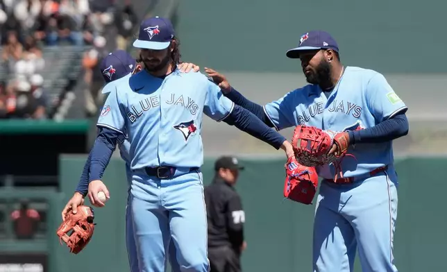 Toronto Blue Jays pitcher Dylan Cease, middle, reacts with shortstop Andrés Giménez, left, and first baseman Vladimir Guerrero Jr. after San Francisco Giants' Heliot Ramos hit a single during the ninth inning of a baseball game Wednesday, July 8, 2026, in San Francisco. (AP Photo/Jeff Chiu)