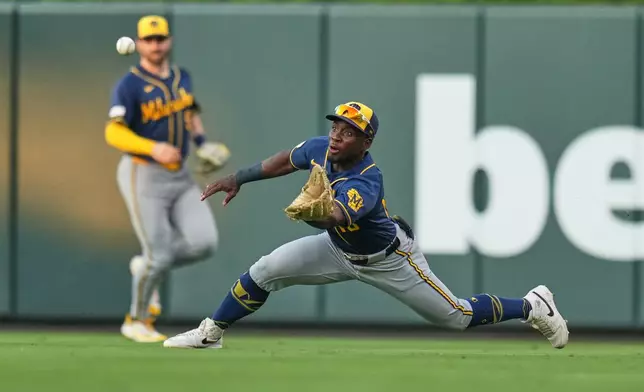 Milwaukee Brewers right fielder Luis Lara, right, dives to catch a fly ball by St. Louis Cardinals' Iván Herrera as Brewers center fielder Garrett Mitchell watches during the third inning of a baseball game Wednesday, July 8, 2026, in St. Louis. (AP Photo/Jeff Roberson)