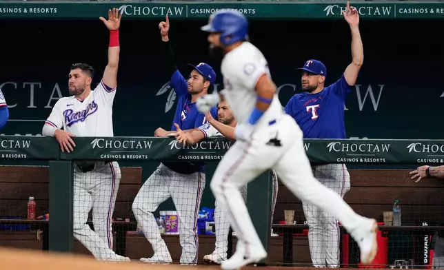 Texas Rangers players celebrate after Ezequiel Duran, front, hit a solo home run in the third inning of a baseball game against the Seattle Mariners in Arlington, Texas, Monday, July 27, 2026. (AP Photo/Tony Gutierrez)