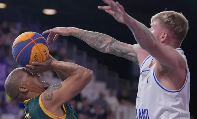 South Africa's Simanga Mbhele, left, attempts to throw a basket as Scotland's Tyler Baines goes to block during their 3x3 basketball match between South Africa and Scotland at the Commonwealth Games in Glasgow, Scotland, Saturday, July 25, 2026. (AP Photo/Alastair Grant)