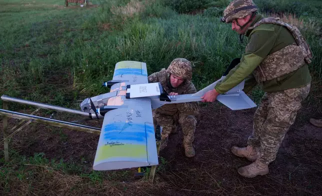 Ukrainian servicemen of K-2 brigade of the Unmanned Systems Forces prepare a midrange drone at takeoff position before flying towards Russian positions at the frontline in Donetsk region, Ukraine, Monday, June 22, 2026. (AP Photo/Evgeniy Maloletka)