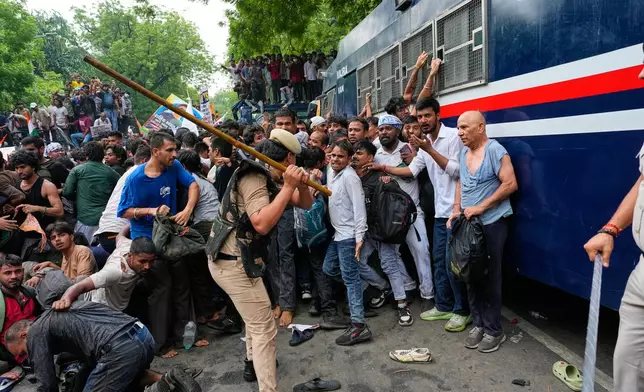 Police use batons to disperse supporters of the Cockroach Janta Party as they attempt to march toward India's Parliament, demanding the resignation of the education minister, in New Delhi, India, Monday, July 20, 2026. (AP Photo/Manish Swarup)