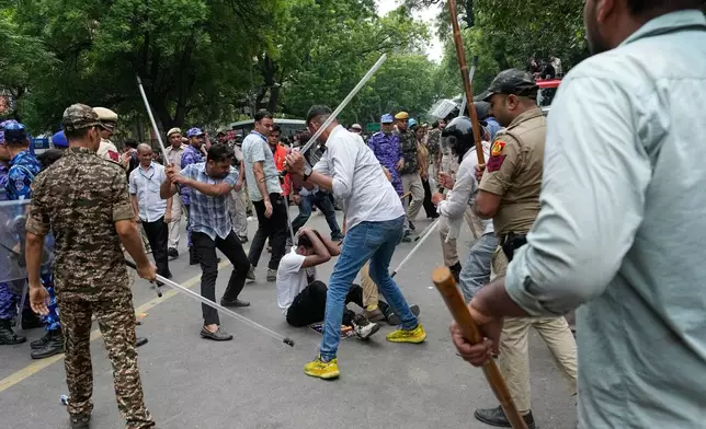Police use batons to disperse supporters of the Cockroach Janta Party as they attempt to march toward India's Parliament, demanding the resignation of the education minister, in New Delhi, India, Monday, July 20, 2026. (AP Photo/Manish Swarup)