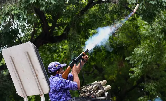 A policeman fires tear gas to disperse supporters of the Cockroach Janta Party as they attempt to march toward India's Parliament, demanding the resignation of the education minister, in New Delhi, India, Monday, July 20, 2026. (AP Photo/Manish Swarup)