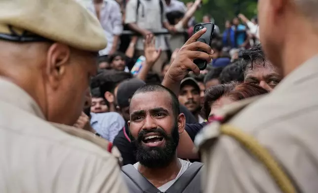 A supporter of the Cockroach Janta Party reacts during clashes with police as they attempt to march toward India's Parliament, demanding the resignation of the education minister, in New Delhi, India, Monday, July 20, 2026. (AP Photo/Manish Swarup)