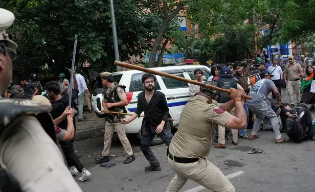 Police use batons to disperse supporters of the Cockroach Janta Party as they attempt to march toward India's Parliament, demanding the resignation of the education minister, in New Delhi, India, Monday, July 20, 2026. (AP Photo/Manish Swarup)