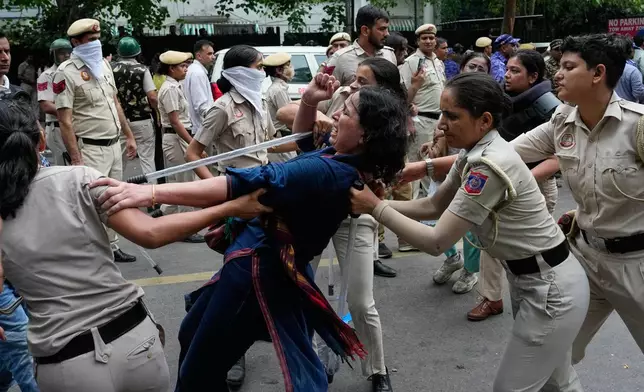 Police detains a supporter of the Cockroach Janta Party as they attempt to march toward India's Parliament, demanding the resignation of the education minister, in New Delhi, India, Monday, July 20, 2026.(AP Photo/Manish Swarup)