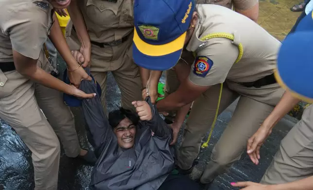 Police officers detain a supporter of the Cockroach Janta Party during a protest demanding the resignation of India's education minister in Mumbai, India, Monday, July 20, 2026.(AP Photo/Rafiq Maqbool)