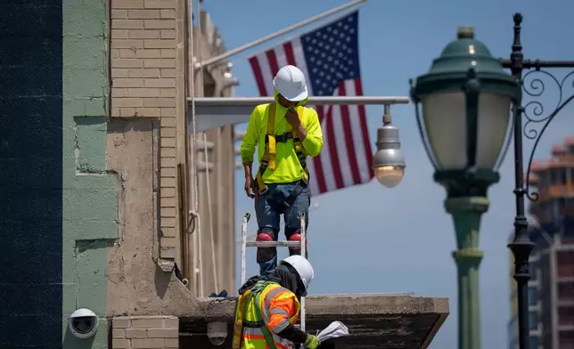 FILE - Workers climb down from a building during a heat advisory, May 19, 2026, in New York. (AP Photo/Adam Gray, File)