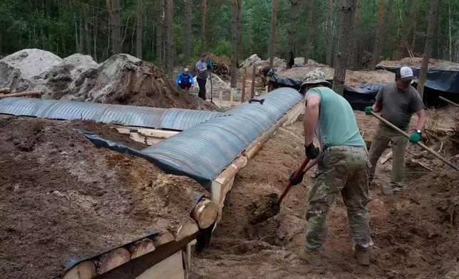 Ukrainian workers build a strongpoint close to the Ukraine-Belarus border in an undisclosed location in Ukraine Tuesday, July 7, 2026. (AP Photo/Efrem Lukatsky)