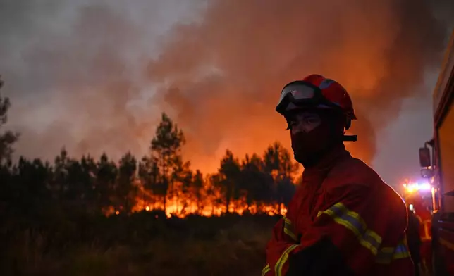 Firefighters battle a blaze outside Lanton, during wildfires in southwestern France, Tuesday, July 28, 2026. (AP Photo/Emma Da Silva)