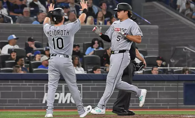 Chicago White Sox's Chase Meidroth (10) and Munetaka Murakami (5) celebrate after scoring on a three-RBI double by teammate Colson Montgomery during the fifth inning of a baseball game against the Toronto Blue Jays in Toronto, Friday, July 17, 2026. (Jon Blacker/The Canadian Press via AP)