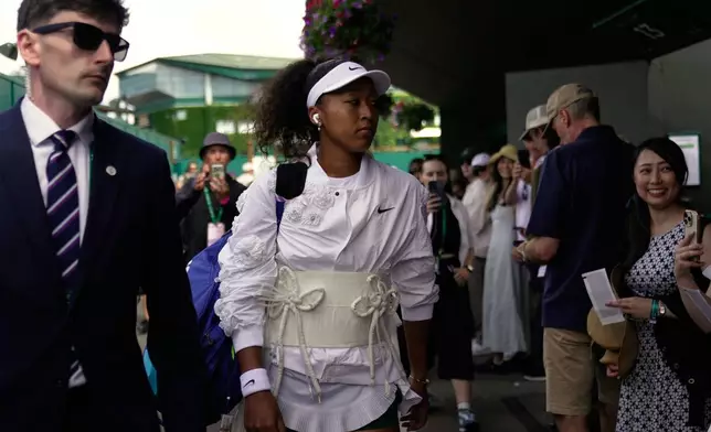 Naomi Osaka of Japan walks towards court 2 to play her second round women's singles match against Anastasia Gasanova of Russia, at the Wimbledon Tennis Championships in London, Wednesday, July 1, 2026. (AP Photo/Brian Inganga)