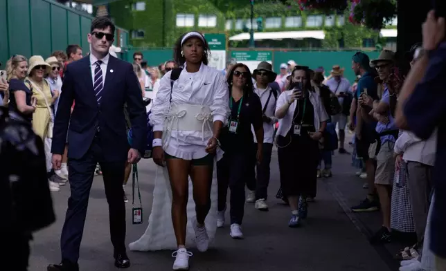 Naomi Osaka of Japan walks towards court 2 to play her second round women's singles match against Anastasia Gasanova of Russia, at the Wimbledon Tennis Championships in London, Wednesday, July 1, 2026. (AP Photo/Brian Inganga)
