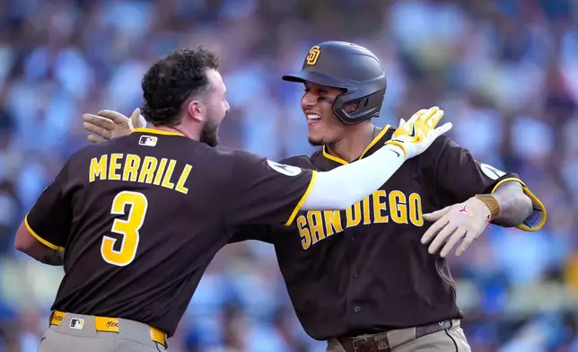 San Diego Padres' Manny Machado, right, is congratulated by Jackson Merrill after hitting a three-run home run during the seventh inning of a baseball game against the Los Angeles Dodgers, Sunday, July 5, 2026, in Los Angeles. (AP Photo/Mark J. Terrill)