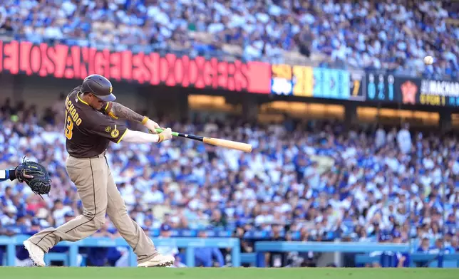 San Diego Padres' Manny Machado hits a three-run home run as during the seventh inning of a baseball game against the Los Angeles Dodgers, Sunday, July 5, 2026, in Los Angeles. (AP Photo/Mark J. Terrill)