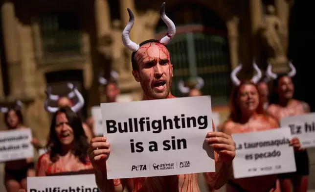 Animal rights activists participate in a protest against bullfighting ahead of the first running of the bulls during the San Fermin festival in Pamplona, northern Spain, Sunday, July 5, 2026. (AP Photo/Miguel Oses)