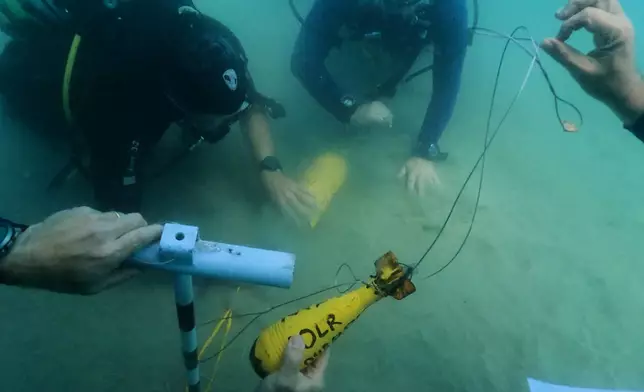 Divers place mock munitions on the floor of the Mediterranean Sea off the coast of Rishon LeZion, Israel, Sunday, June 21, 2026. (AP Photo/Sam Mednick)