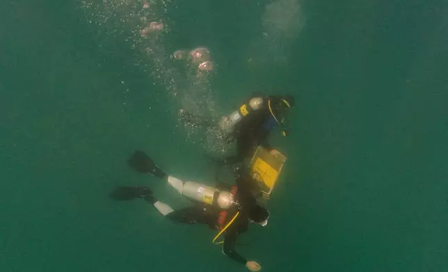 Divers place mock munitions on the floor of the Mediterranean Sea off the coast of Rishon LeZion, Israel, Sunday, June 21, 2026. (AP Photo/Ariel Schalit)