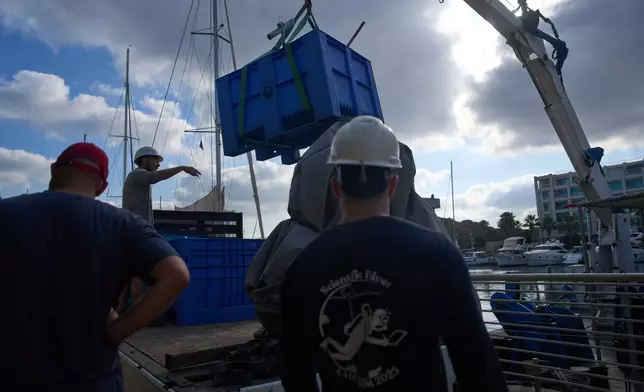 Divers load gear and mock munitions to be placed on the floor of the Mediterranean Sea off the coast of Rishon LeZion, Israel, Sunday, June 21, 2026. (AP Photo/Ariel Schalit)