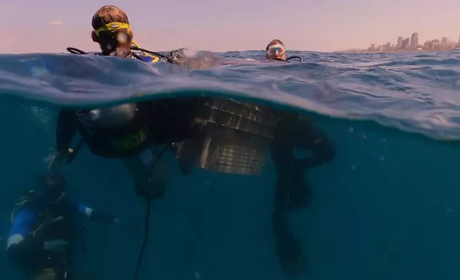 Divers descend to place mock munitions on the floor of the Mediterranean Sea off the coast of Rishon LeZion, Israel, Sunday, June 21, 2026. (AP Photo/Ariel Schalit)