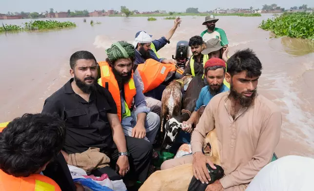Rescue workers evacuate flood victims from a flooded area near Lahore, Pakistan, Monday, Jun 27, 2026. (AP Photo/K.M. Chaudary)