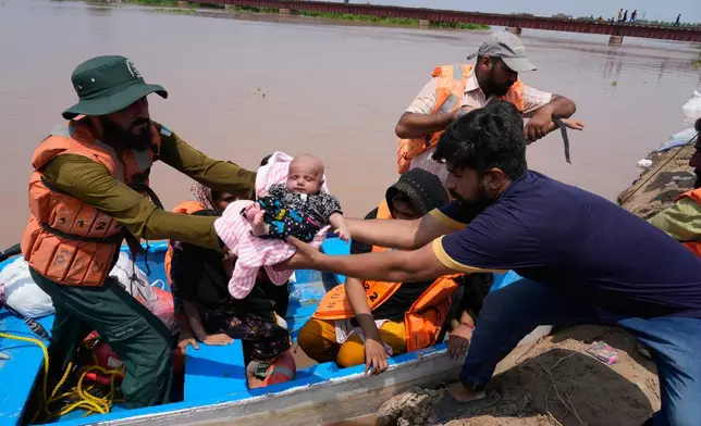 Rescue workers evacuate flood victims from a flooded area near Lahore,Pakistan, Monday, Jun 27, 2026. (AP Photo/K.M. Chaudary)