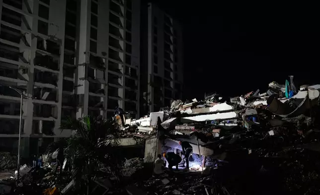 Rescuers search through the rubble of a building that collapsed in the earthquakes in La Guaira, Venezuela, Tuesday, June 30, 2026. (AP Photo/Ariana Cubillos)
