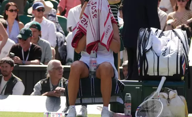 Iga Swiatek of Poland rests under her towel during the third round women's singles match against Alexandra Eala of the Philippines at the Wimbledon Tennis Championships in London, Saturday, July 4, 2026.(AP Photo/Maja Smiejkowska)