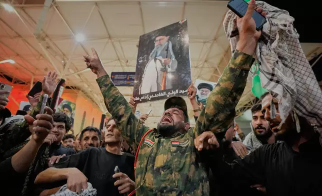 An Iraqi Shiite soldier chants on the eve of funeral ceremonies for the late Iranian Supreme Leader Ayatollah Ali Khamenei outside the Imam Ali Shrine in Najaf, Iraq, Tuesday, July 7, 2026. (AP Photo/Hadi Mizban)