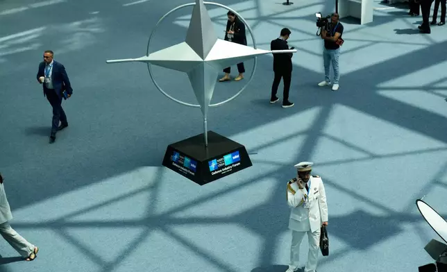 Participants walk near displays during the NATO Defense Industry Forum at the NATO summit in Ankara, Turkey, Tuesday, July 7, 2026. (AP Photo/Hussein Malla)
