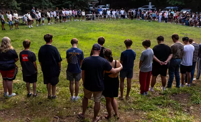 Community members gather during a student-organized vigil at Duncan Woods in Grand Haven, Mich. on Sunday, July 26, 2026, to grieve and honor eight members of a local family who died in a tragedy that has stunned the lakeshore community. (Isaac Ritchey /The Grand Rapids Press via AP)