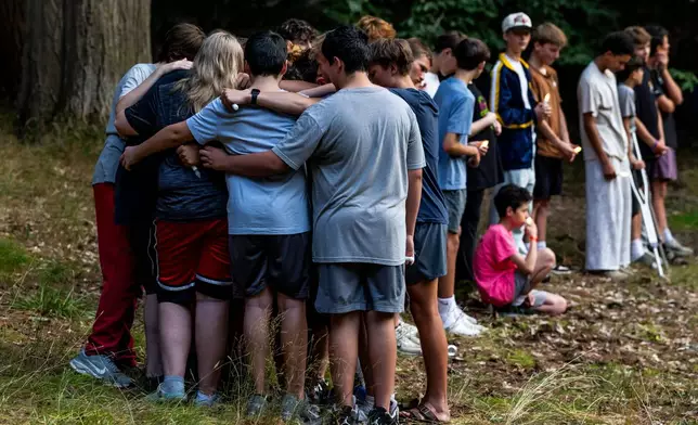Community members gather during a student-organized vigil at Duncan Woods in Grand Haven, Mich. on Sunday, July 26, 2026, to grieve and honor eight members of a local family who died in a tragedy that has stunned the lakeshore community. (Isaac Ritchey/The Grand Rapids Press via AP)