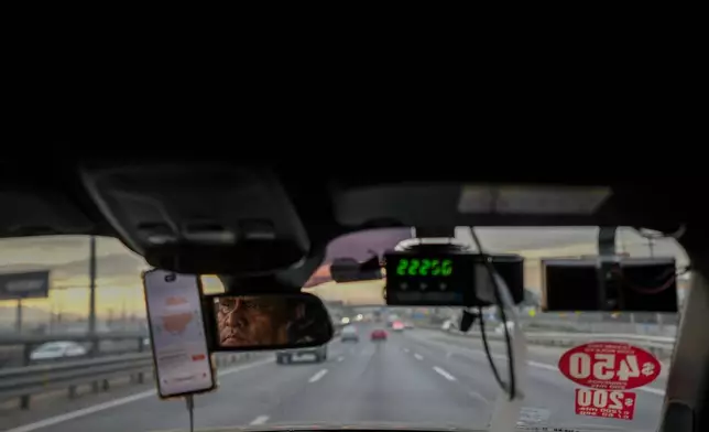 Taxi driver Felipe Molina drives along a street in Santiago, Chile, on Friday, July 10, 2026. (AP Photo/Esteban Felix)