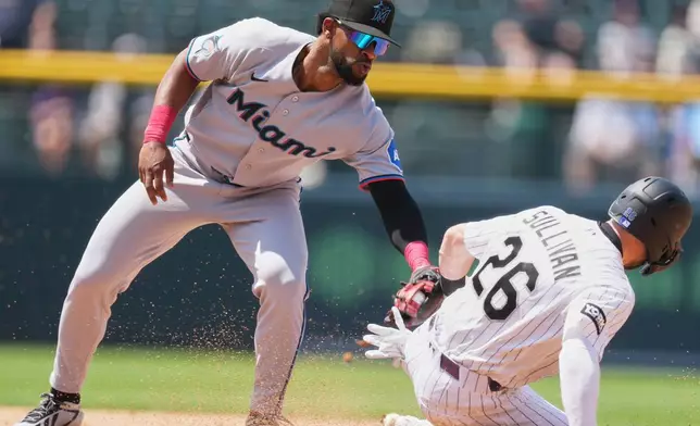 Miami Marlins shortstop Otto Lopez, left, tags out Colorado Rockies' Brett Sullivan as he tries to steal second base in the fourth inning of a baseball game Thursday, July 2, 2026, in Denver. (AP Photo/David Zalubowski)